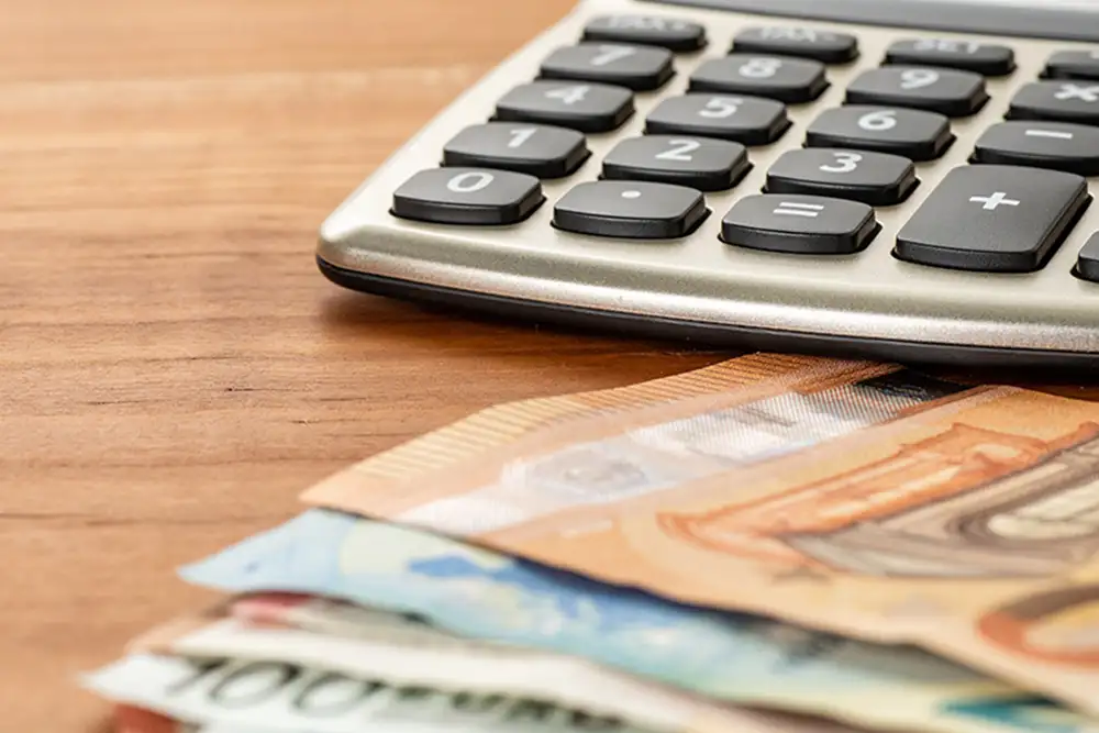 Energie sparen: Münzen in Glühbirne auf Unterlagen